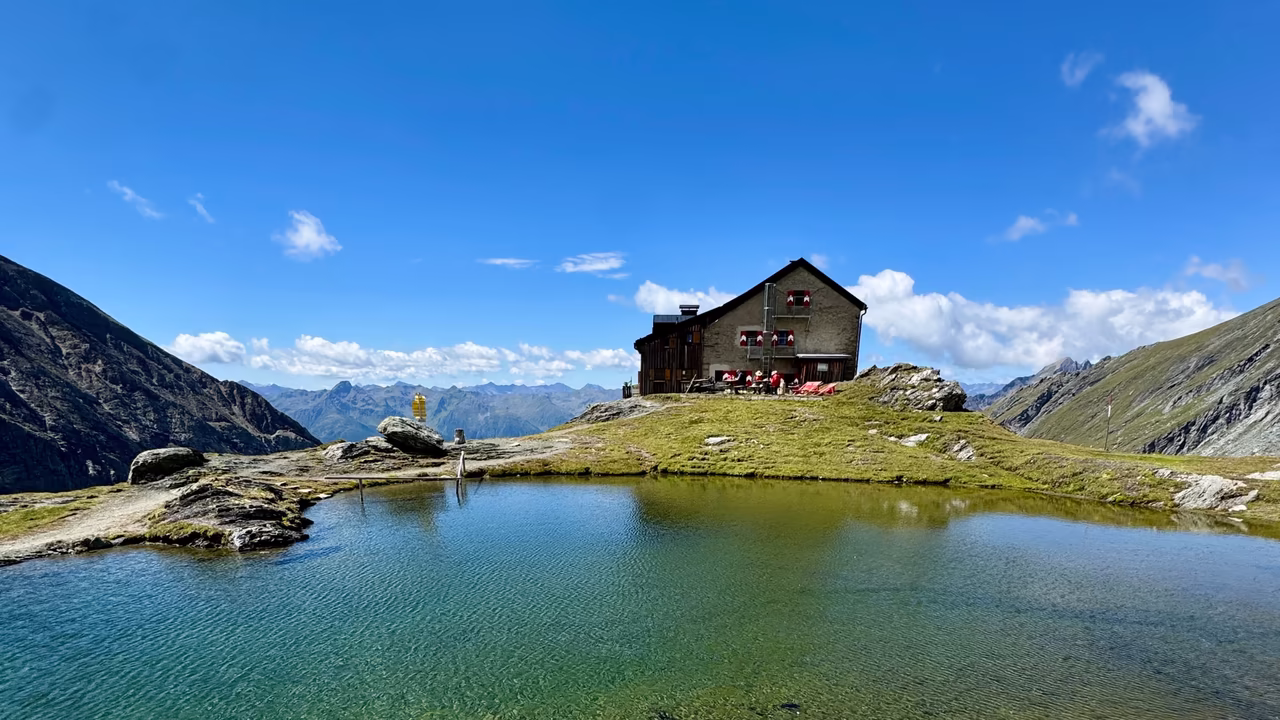 Berghütte vor einem kleinen Bergsee
